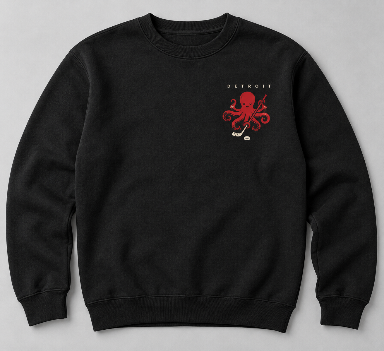 Black crewneck sweatshirt with small ivory Detroit lettering above a red octopus holding a hockey stick beside an ivory puck