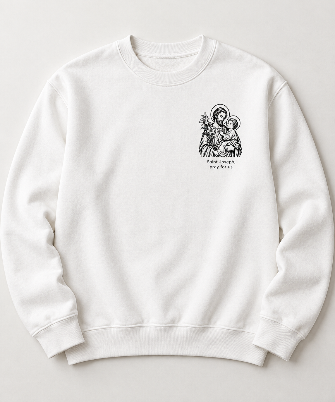 Light crewneck sweatshirt with a small black illustration of Saint Joseph holding Jesus and the prayer Saint Joseph, pray for us beneath