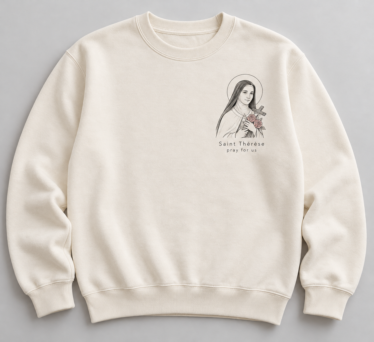Cream concept crewneck sweatshirt with a small charcoal portrait of Saint Thérèse holding a crucifix and dusty-pink roses, with the words Saint Thérèse, pray for us